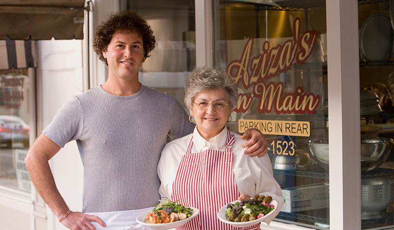 Image of a man and woman standing in front of their bakery